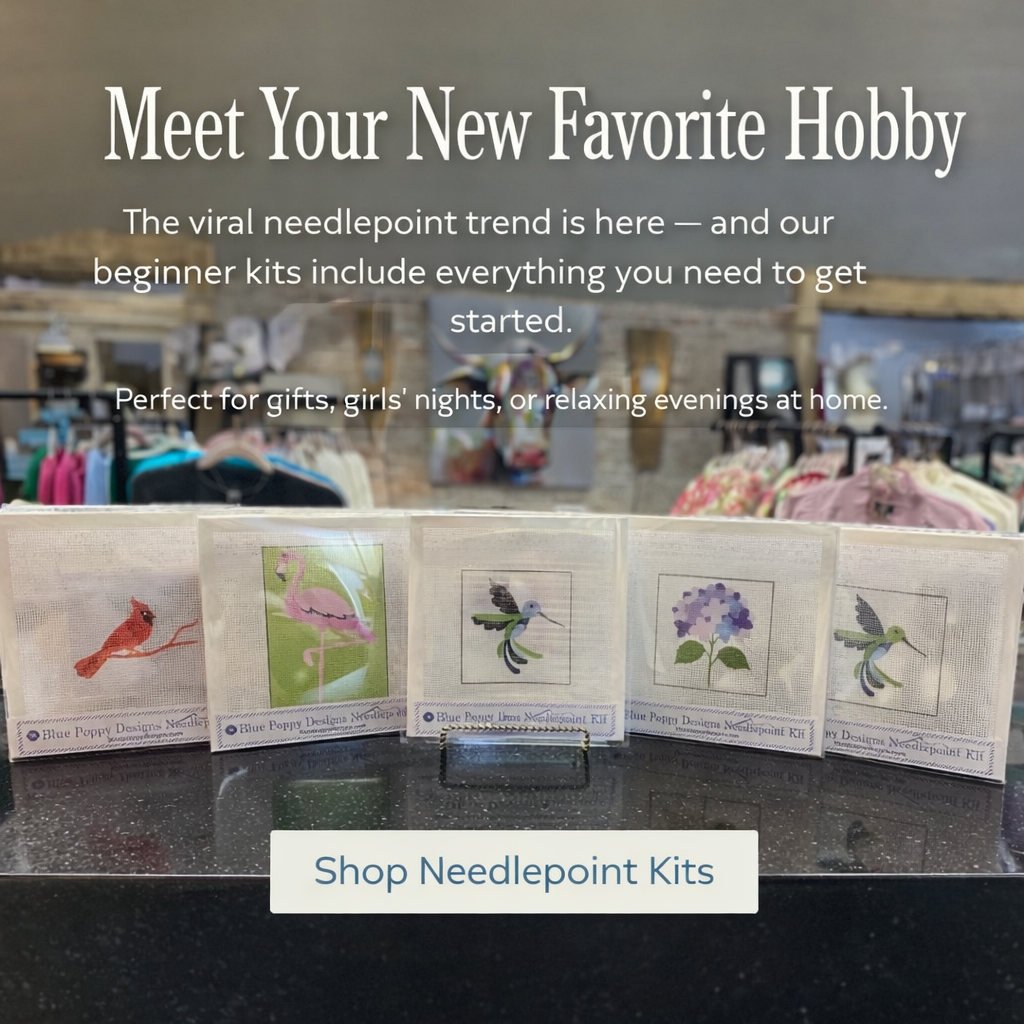 Needlepoint kits displayed on a counter with promotional text about the viral needlepoint trend.